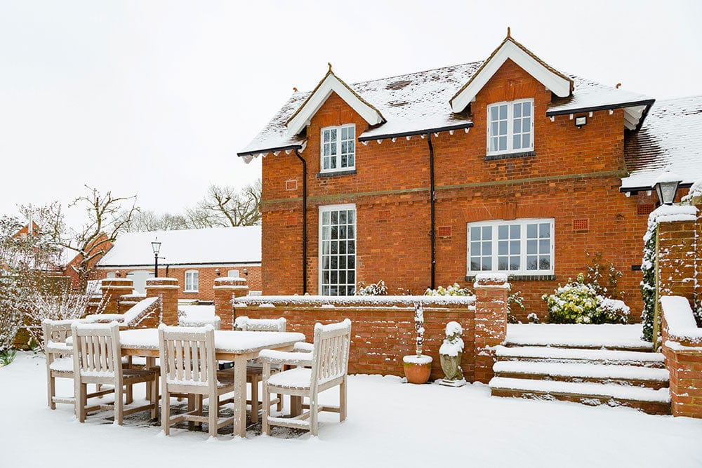 Wallpaper mural for home decoration featuring a red house with snow covering it.