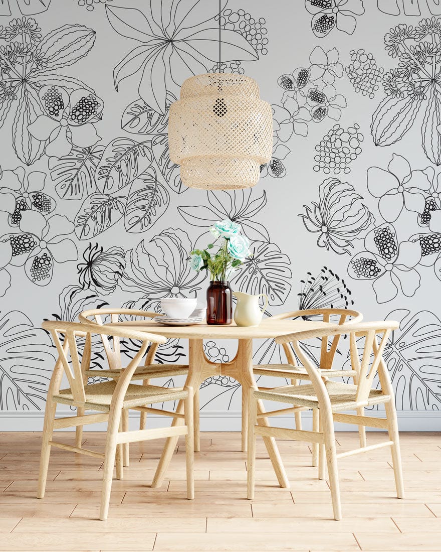 Monochrome botanical wallpaper in dining room, wooden chairs, light flooring, wicker pendant lamp. Elegant style.