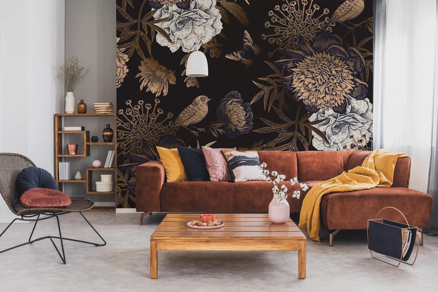 Vintage botanical noir wallpaper with birds, butterflies; brown sofa, wooden coffee table, bookshelf, pendant light.