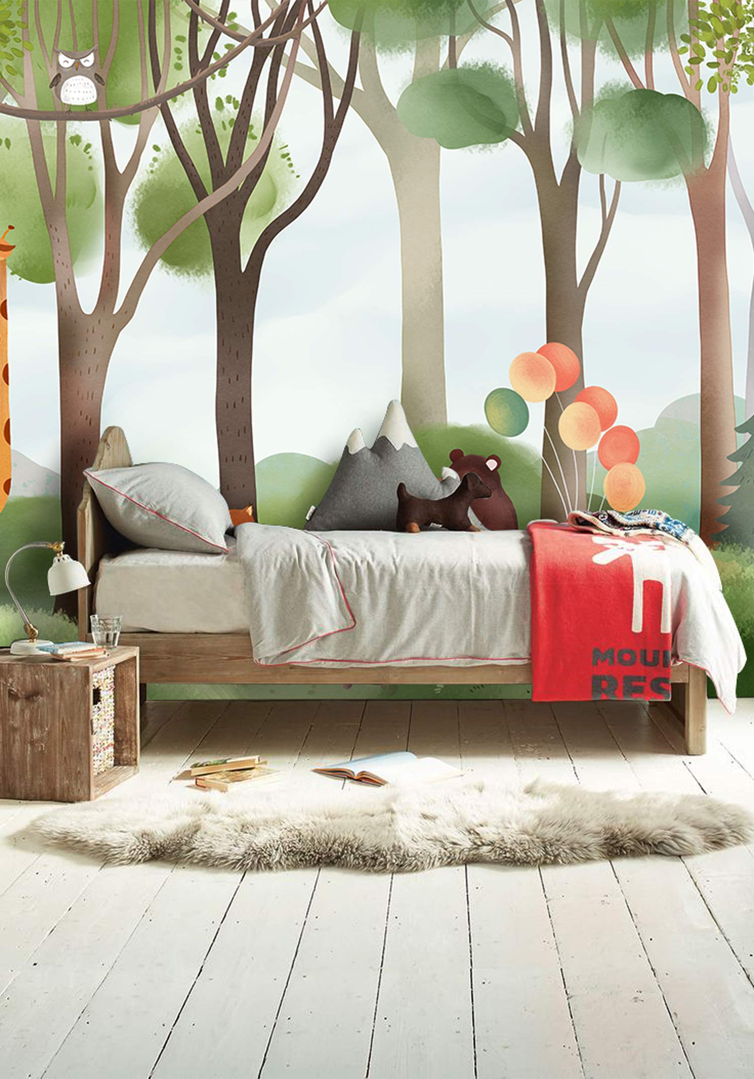Whimsical forest mural wallpaper in child's room with wooden bed, colourful balloons, and light flooring.