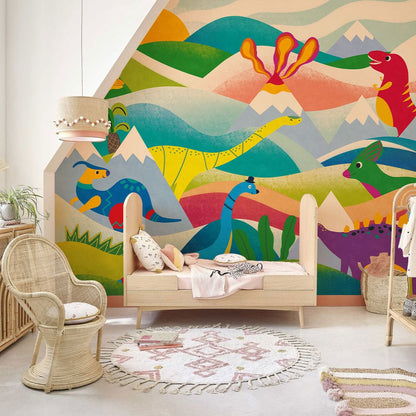 Wallpaper mural for a nursery decorated with colourful mountains and dinosaurs.