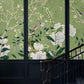 a traditional wallpaper mural in green with birds and flowers for a stairwell