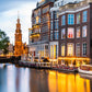 shops in Amsterdam by shore turn lights on early before dusk customized wallpaper