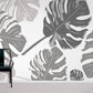 Wallpaper with a repeating pattern of large grey leaves, used for home decoration