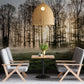 A dining room has a wall mural of a misty forest at dawn