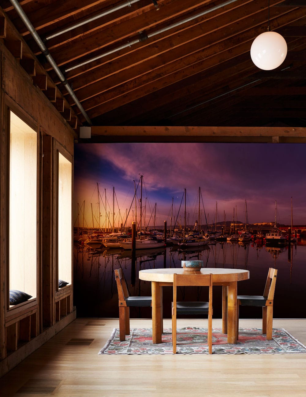 Wallpaper mural depicting a harbor with sailboats and a sunset for the dining room.