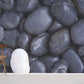 Wallpaper mural for home decoration with a white pebble embedded in a black pebble design.