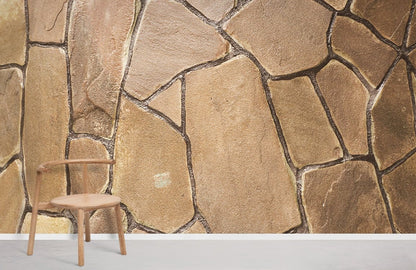 Room with a rundown brown brick wall covered with wallpaper and a mural