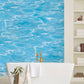Wallpaper mural with sky blue waves for use as bathroom decor.
