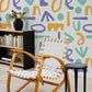 Mural wallpaper design featuring colourful letters, perfect for decorating the living room.