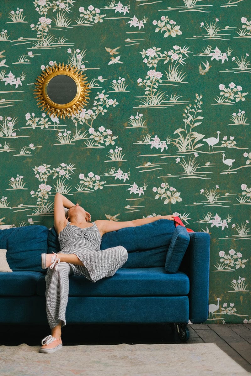 Decorate your living room with this mural of wild flowers on a green wallpaper.